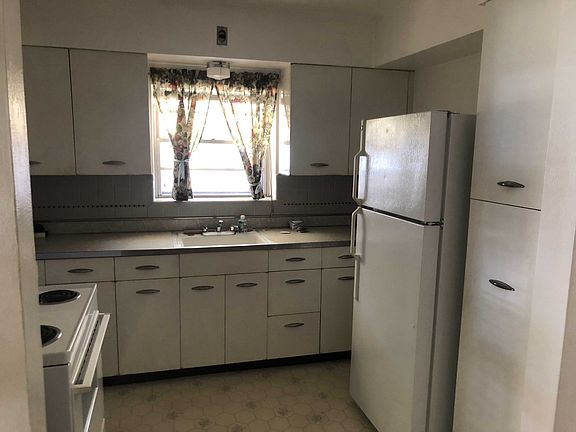 Kitchen with fridge and electric oven.