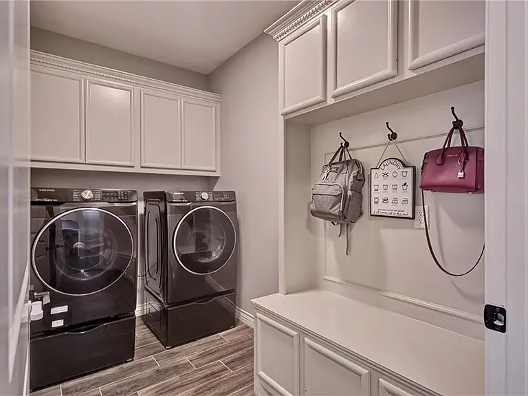 Convenient utility room with washer and dryer, offering direct access to the two-car garage.