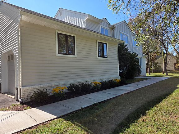 "Charming front path featuring vibrant Black-eyed Susans and manicured shrubs."