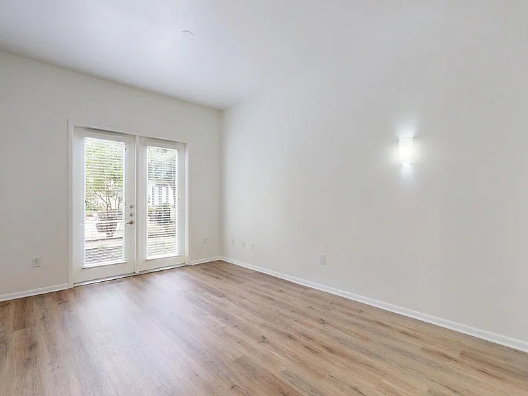 Apartment living room with balcony and wood style floors.