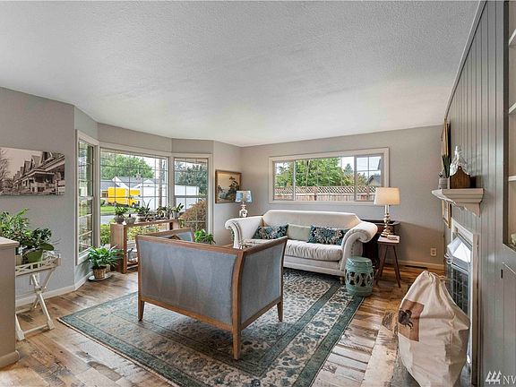 The living room shines with reclaimed wood floor, gas fireplace and enormous bay windows that let in tons of natural light. 
