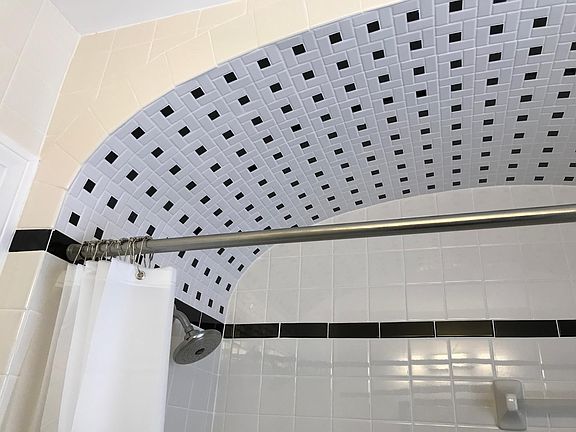 New tile and fixtures in bathroom; beautiful arch over tub
