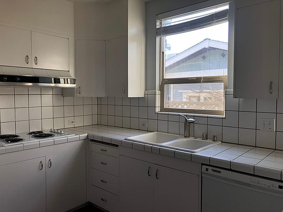 Kitchen with double oven, electric glass cooktop, dishwasher and refrigerator.