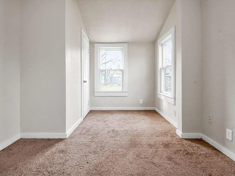 Second bedroom with carpet. The door is for the closet.