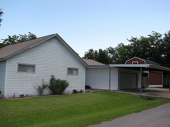 SIDE OF HOME SHOW 3 CAR CARPORT AND THE GARAGE