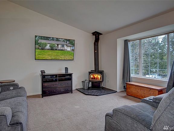 Living room with vaulted ceilings and cozy woodstove.