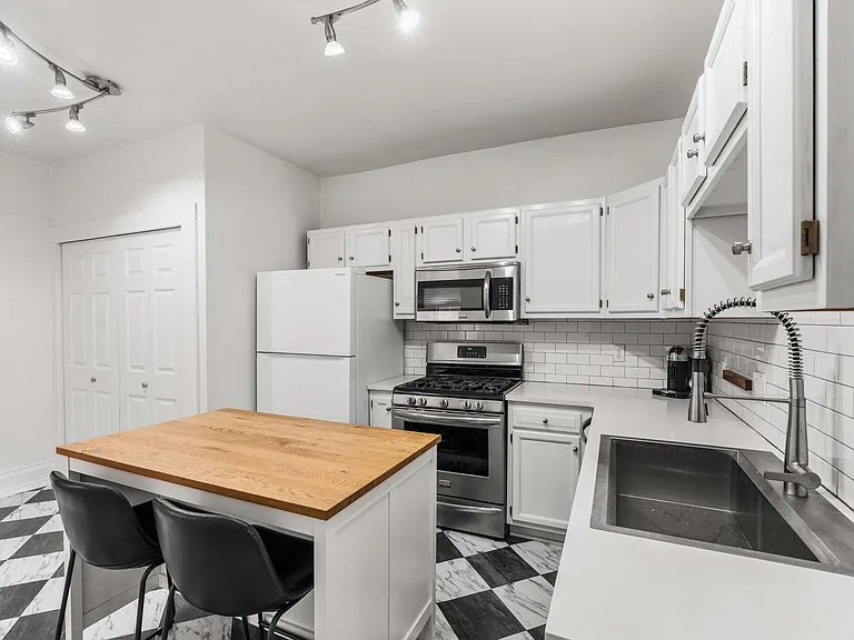 Bright kitchen featuring stainless steel appliances and an oversized island perfect for cooking or entertaining.