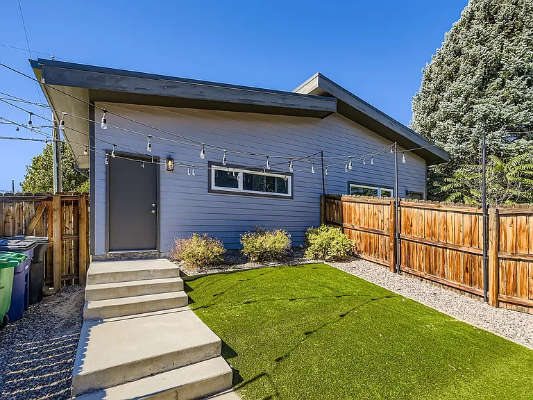 Backyard walkway to detached 2-car garage, artificial turf and bistro lights