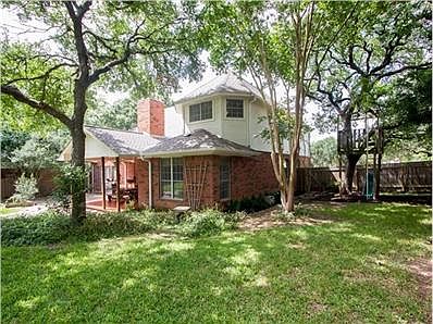 Wooded backyard with tree house and four sides masonry.