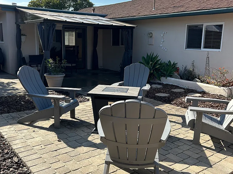 Backyard and covered patio. BBQ and fruit trees (orange, peach, and plum trees). There is a lovely view of La Cumbre Peak.