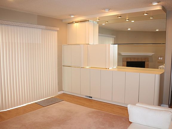Built in wall unit in living room with bar and recessed lights, sliders to balcony