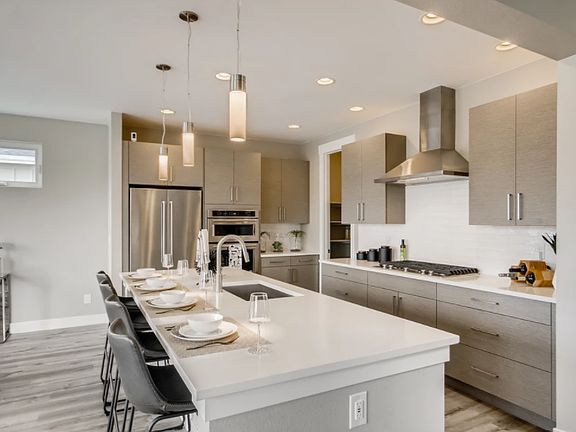 Beautifully modern kitchen with spacious island, upgraded stainless steel appliances and gas range.