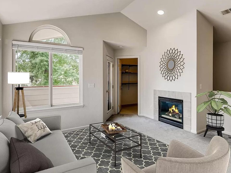 Living room with vaulted ceilings and large windows that allow for abundant natural light. Large storage closet off to the side.