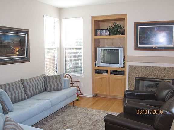 Great room with oak flooring, built-in media center and granite tile fireplace