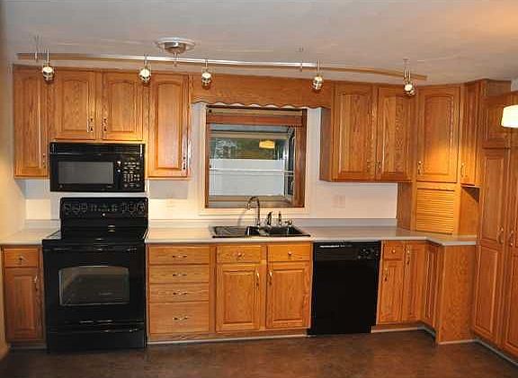 Kitchen:  Hardy oak cabinets, black appliances, pantry, new lighting & floor