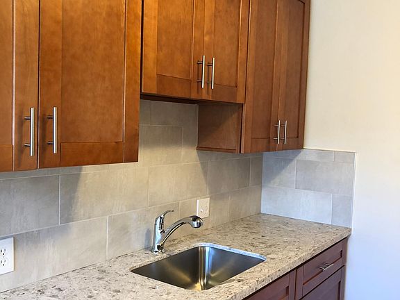 Kitchen with quartz countertops, tile backsplash.