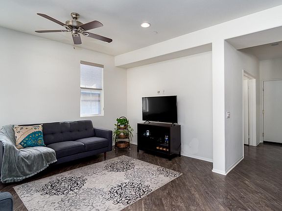 View of living room with hall on the right toward den on the left, full bath on the right and garage in the back.