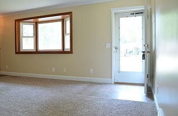 Welcome home!  This view is from the dining room and shows the front door entryway off the living room with bay window.  New paint and carpet throughout.