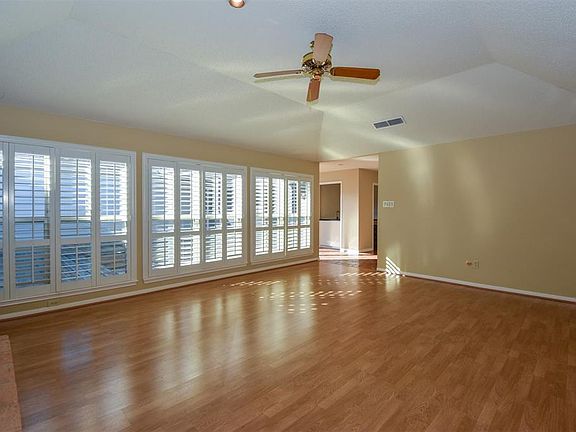 As you enter through double front doors, to your left you are welcomed into an oversized light and bright living area with a tray ceiling and where Planation shutters grace the double paned windows.