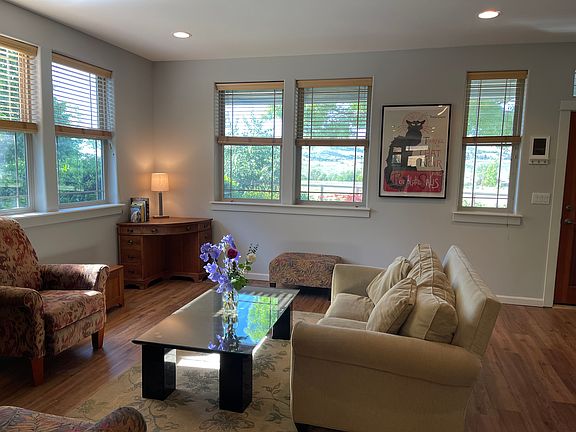View of living room looking toward front porch, Grizzly Peak and park.