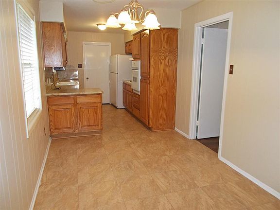 Light & bright breakfast room has updated light fixture, tiled floor, 2" blinds