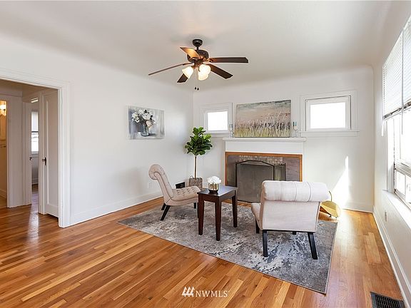 Living room with hardwood floors, wood burning fireplace and loads of sunlight