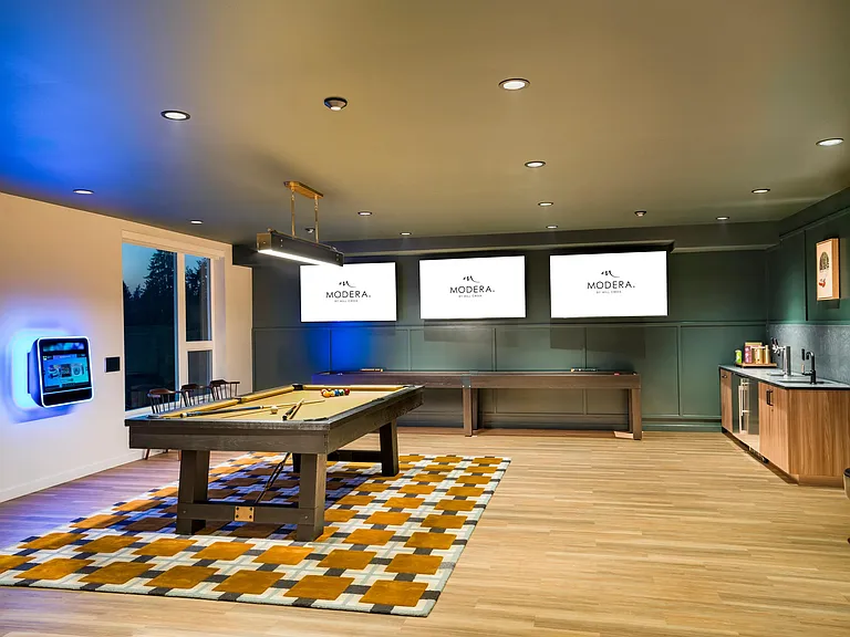 Gather with friends in Modera Shoreline's game lounge, featuring billiards, large screens, and space to unwind just minutes from downtown Shoreline.
