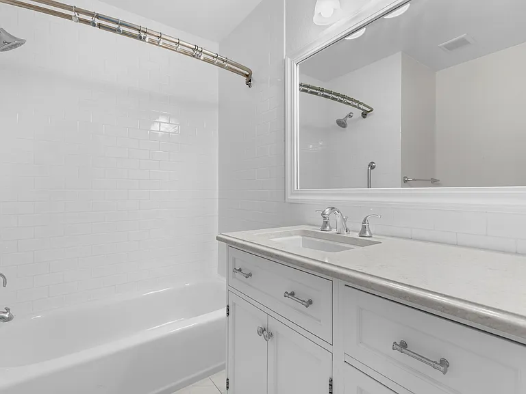 The upstairs secondary bathroom features an updated vanity, generous cabinet and storage space, and a tub/shower combination.