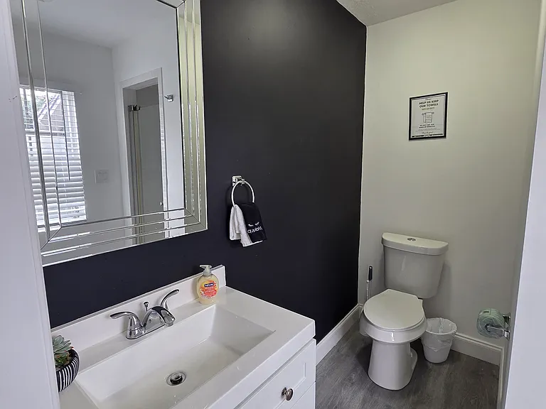 Stylish bathroom featuring shower, toilet, sink, and fresh towels.