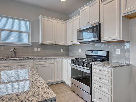 Kitchen with bright white cabinets and an large island.