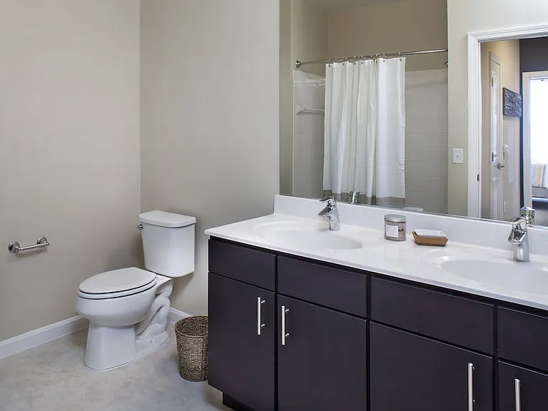 Classic Package I bath with white porcelain countertops, dark cabinetry, and hard surface flooring