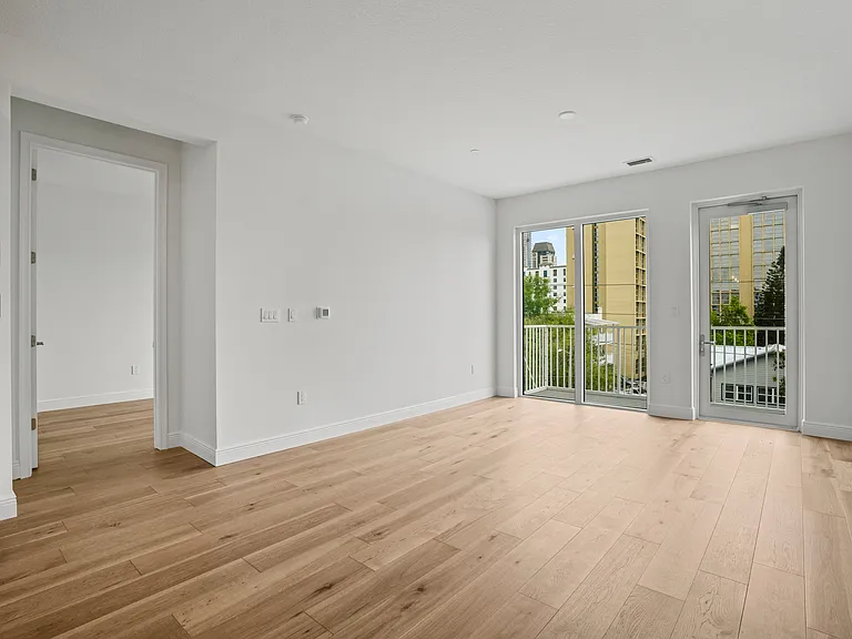 Open Living spacious room. This area is designed for both relaxation and entertaining, featuring a generous layout that allows for comfortable movement and flexible furniture arrangements. Natural light floods the space, enhancing its airy and welcoming a