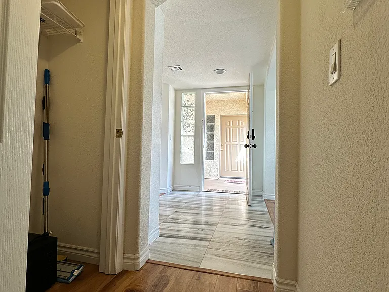 View of hallway going back to the entrance from the second bathroom and bedroom.