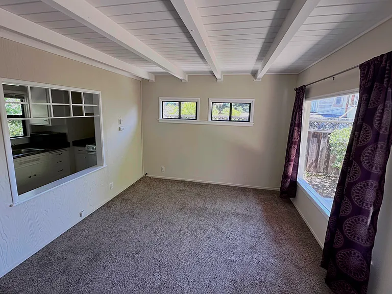 Living room with kitchenette access window on the left hand side. This "window" connects you to the kitchenette and provides beautiful like to the kitchen spaces