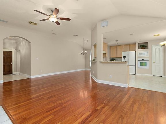 Here you can see the entryway and stunning hardwood floors throughout the living areas. To the right of the front door you will find two secondary bedrooms and a full bathroom. This is a true "split-plan" with the primary room toward the back of the 