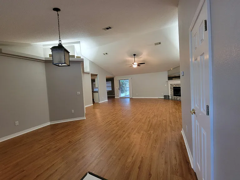 View from front door (Coat closet to right, Bonus area to left, Living Room with wood burning fireplace)