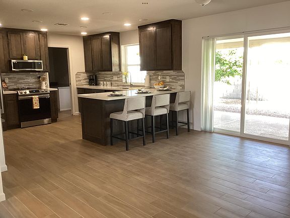 Door to huge back patio with bbq grill and dining table with sitting area