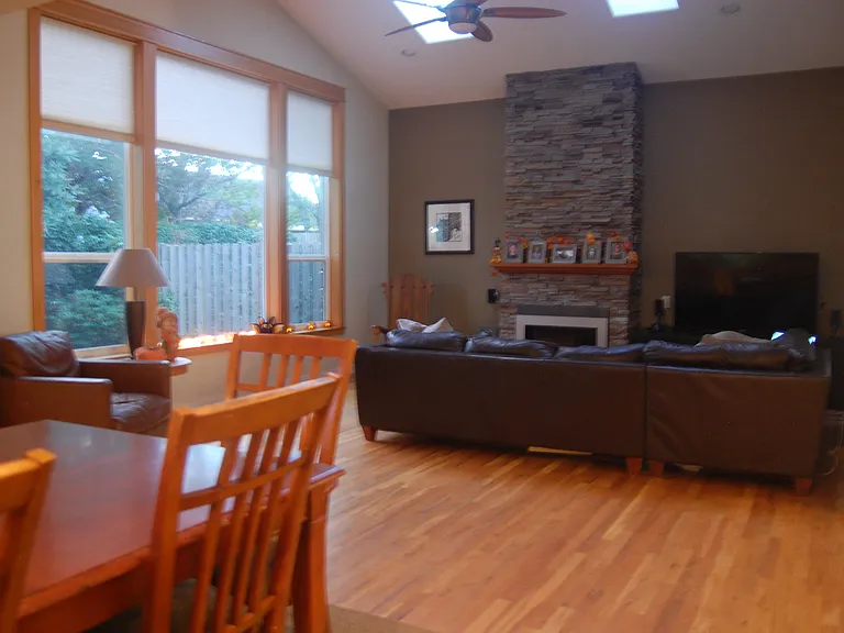 Living Room Oak Hardwood Floors, Large Bank of Windows and Stone Fireplace.