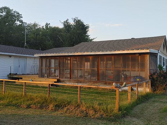 Sunroom, deck, and fenced backyard.