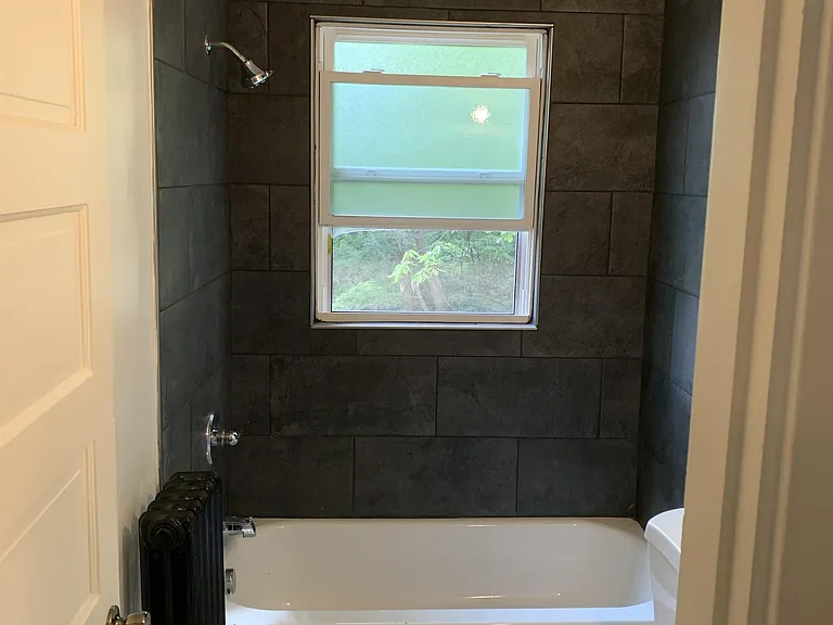 New tile floor, tile surround and tub, toilet and vanity