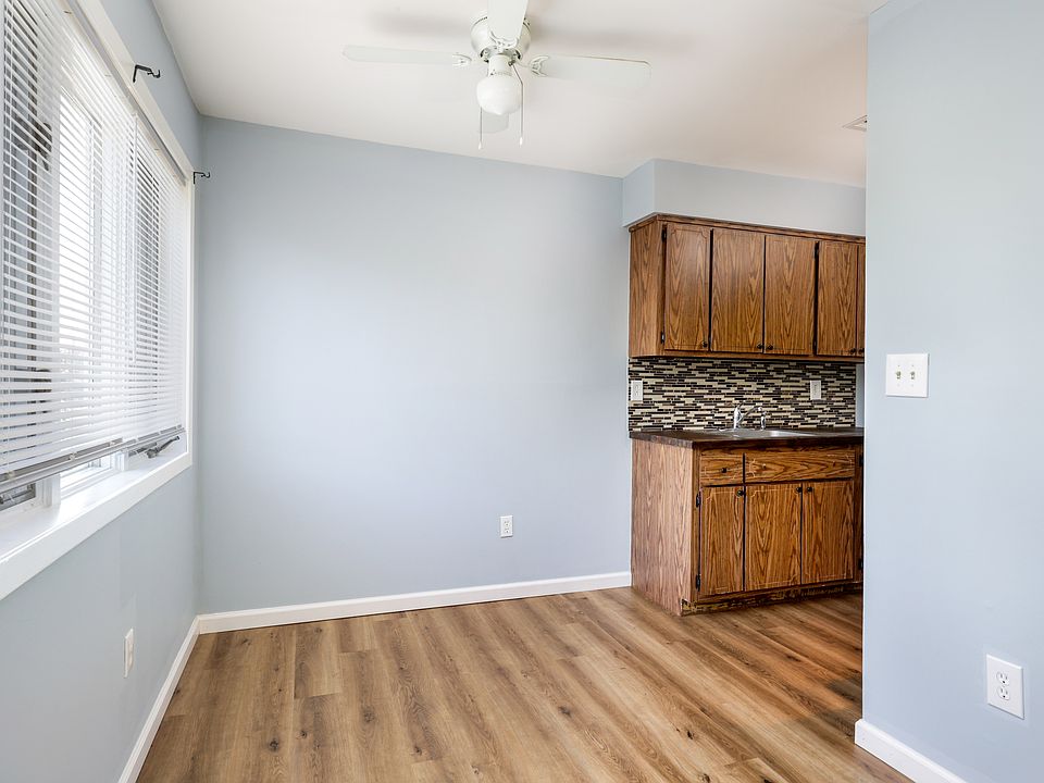 Dining area has a ceiling fan and large windows that bring in great natural light.