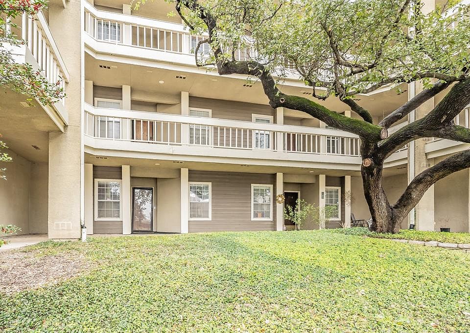 View of front of house with a front yard with a large shade tree.