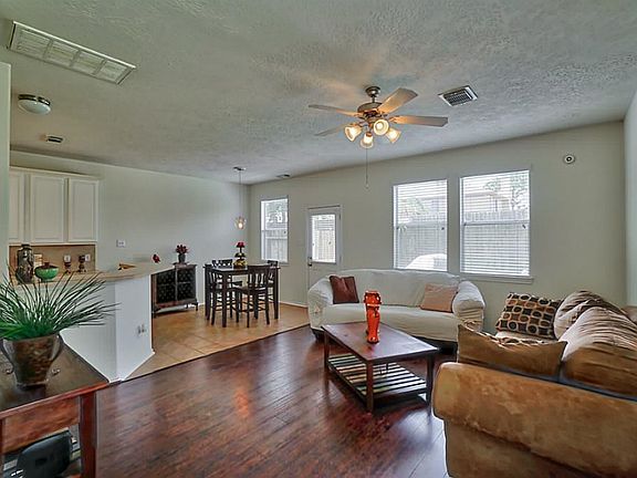 The beautiful living room opens up to the kitchen and features laminate flooring.