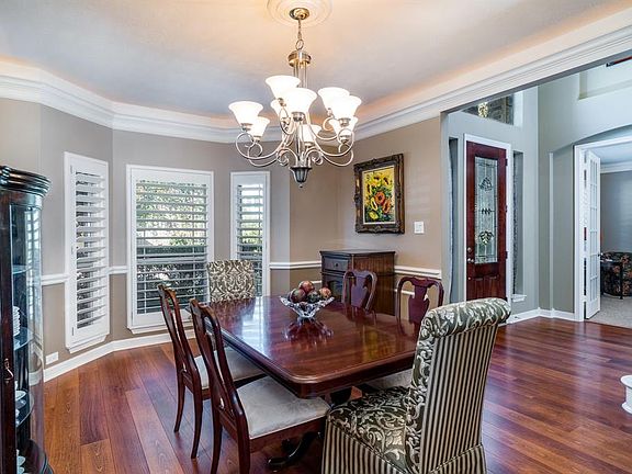 Fabulous formal dining with easy to maintain flooring, plantation shutters, chair & crown molding with decorative lighting provides such ambience!