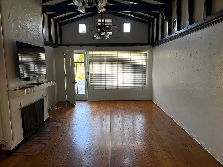 Interior, front door, fireplace on L, hallway to BA and 2 BR on R