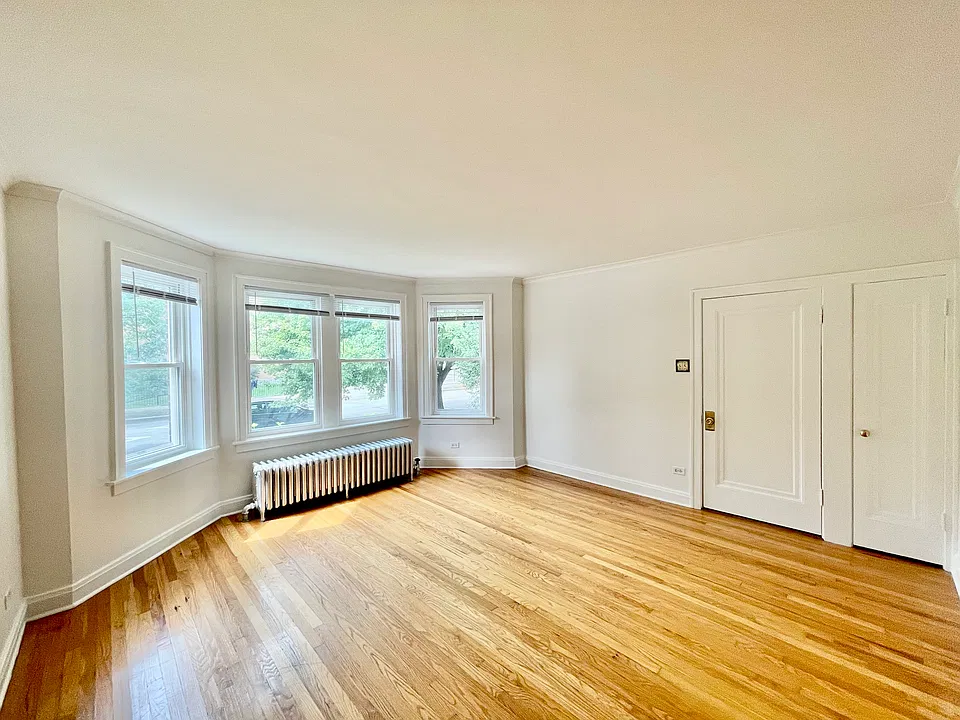 Spacious, sun-drenched living room with bay windows.