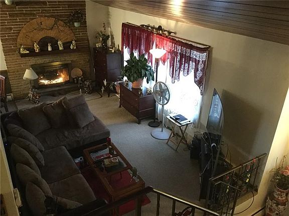 Living room with a fireplace focal point and a stunning wood finished cathedral ceiling.