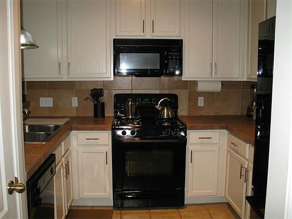 This is entrance to a nice kitchen with Tile counter tops and lots of cabinet space and pantry to the left