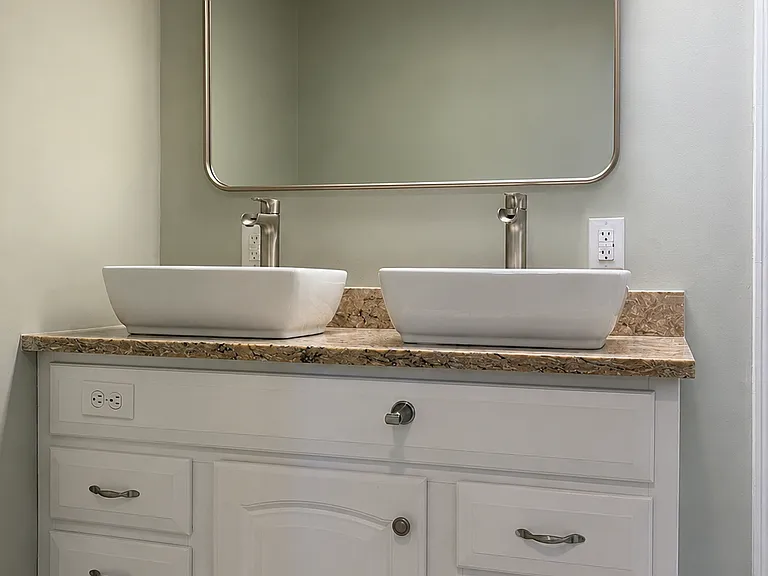 Spacious primary bathroom with a double-sink vanity, walk-in shower, and generous cabinet storage.