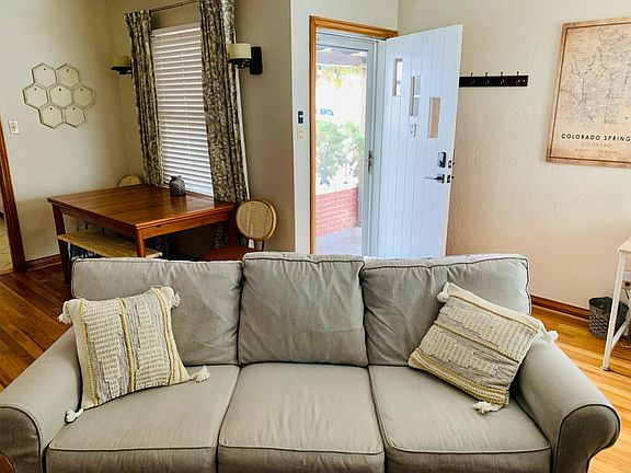 The front entrance leads into the livingroom area with a corner desk and dining space around the corner.